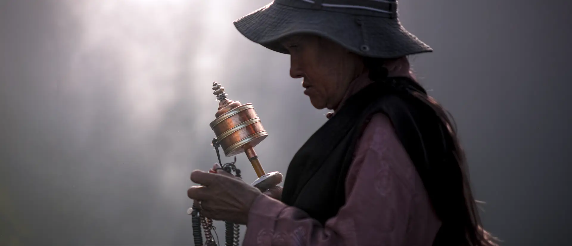 Tibetan pilgrim silhouetted on a monastery bridge