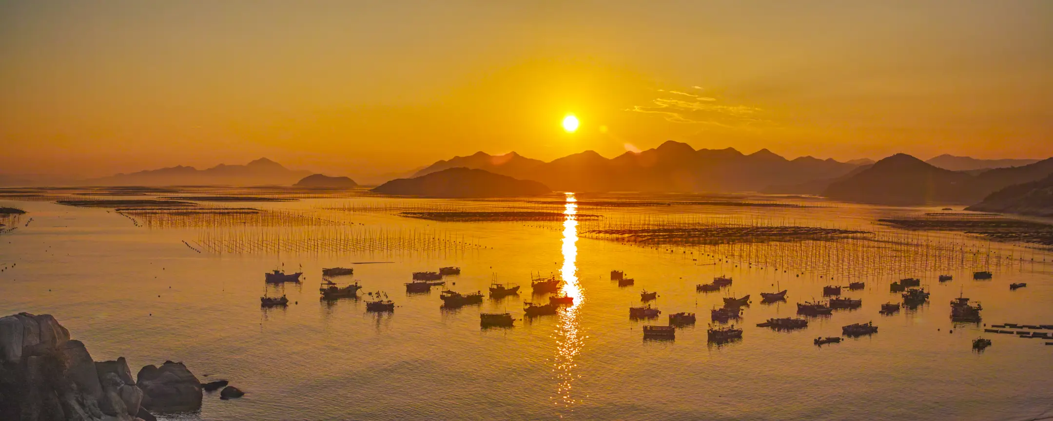 Golden sunset over Dongbi Bay, Xiapu — boats and bamboo poles
